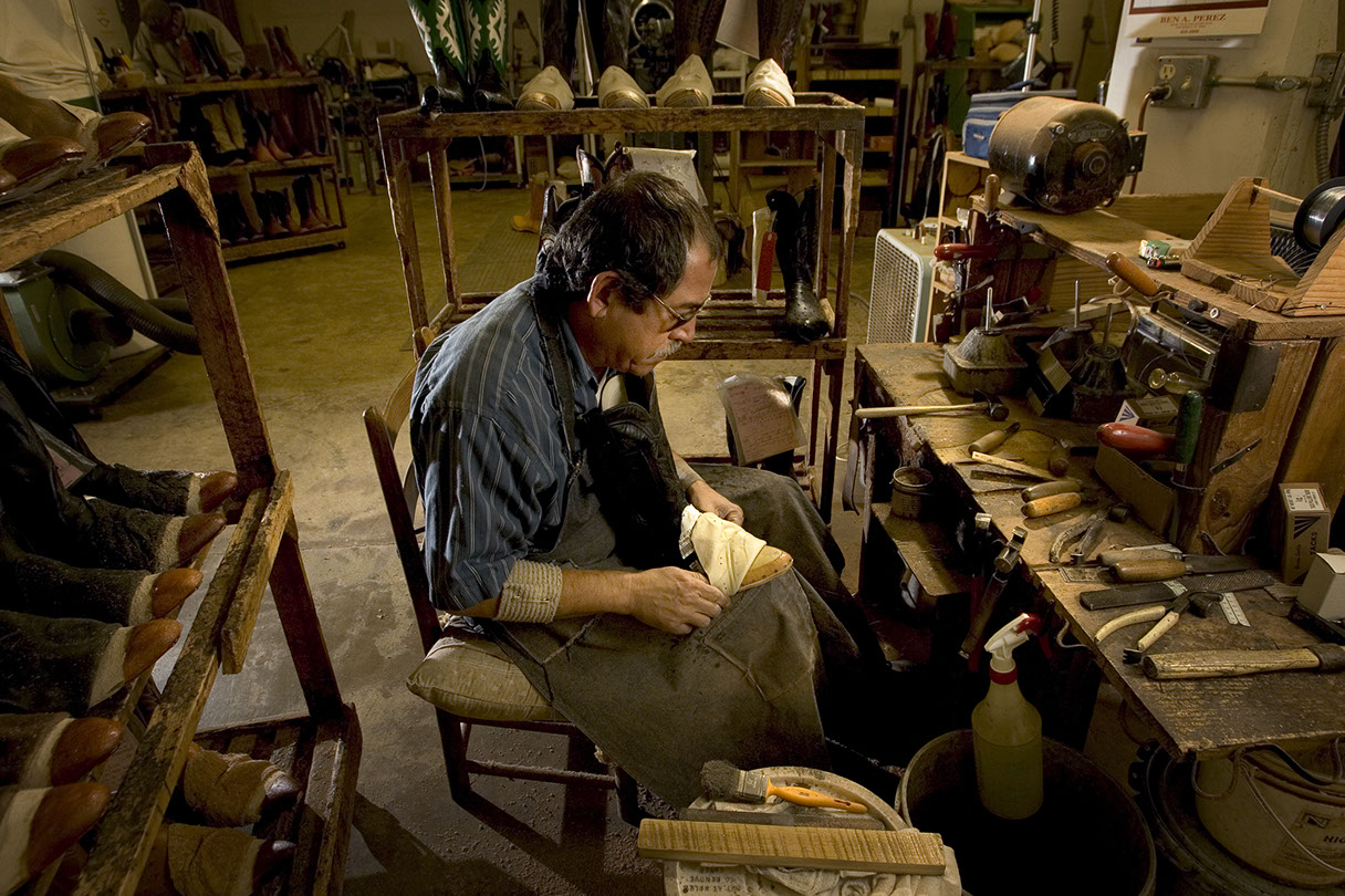 A Leddy's bootmaker hand-finishing a custom boot at his bench in the San Angelo workshop