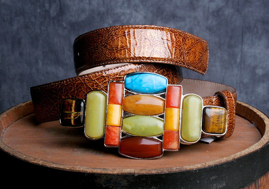 A hand-tooled leather belt with a multi-colored stone buckle